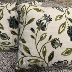 Two decorative pillows with green/blue tulip design.